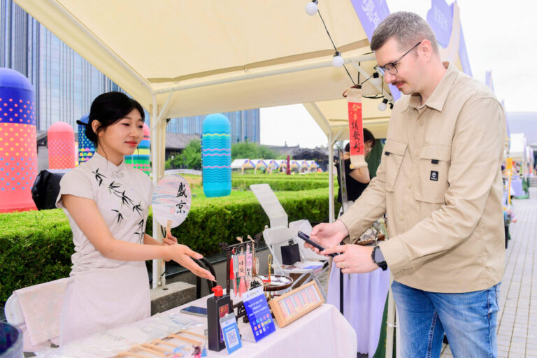 An international visitor paying with Alipay at a souvenir store in China e1729814185216 1024x682